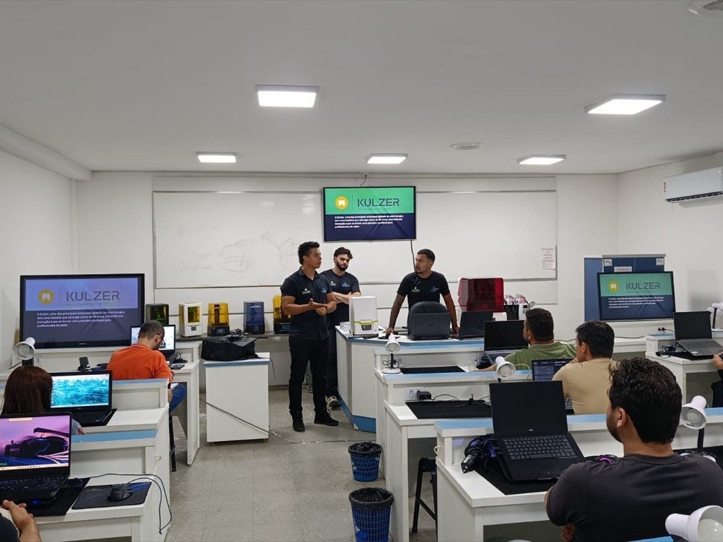 Sala técnica completa do curso: bancadas individuais, impressoras 3D e scanners em operação