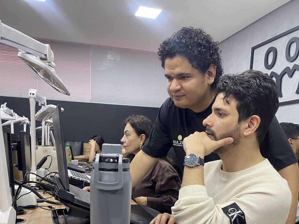 Professor acompanhando aluno de perto na operação do fluxo digital na bancada
